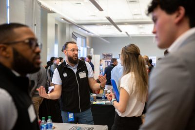 students at a career fair discussing internships